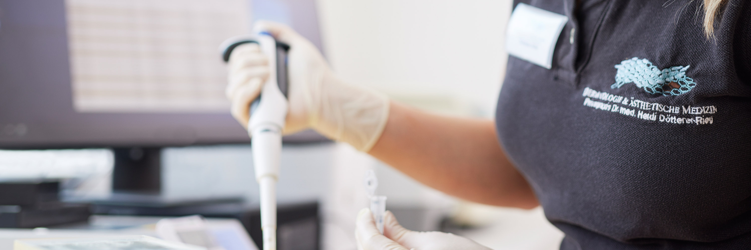 In the practice's laboratory for diagnosing fungi and allergens, a medical assistant evaluates the results of an examination with a computer. To enrich the sample, she fills a test tube in the mycological laboratory with a pipette.