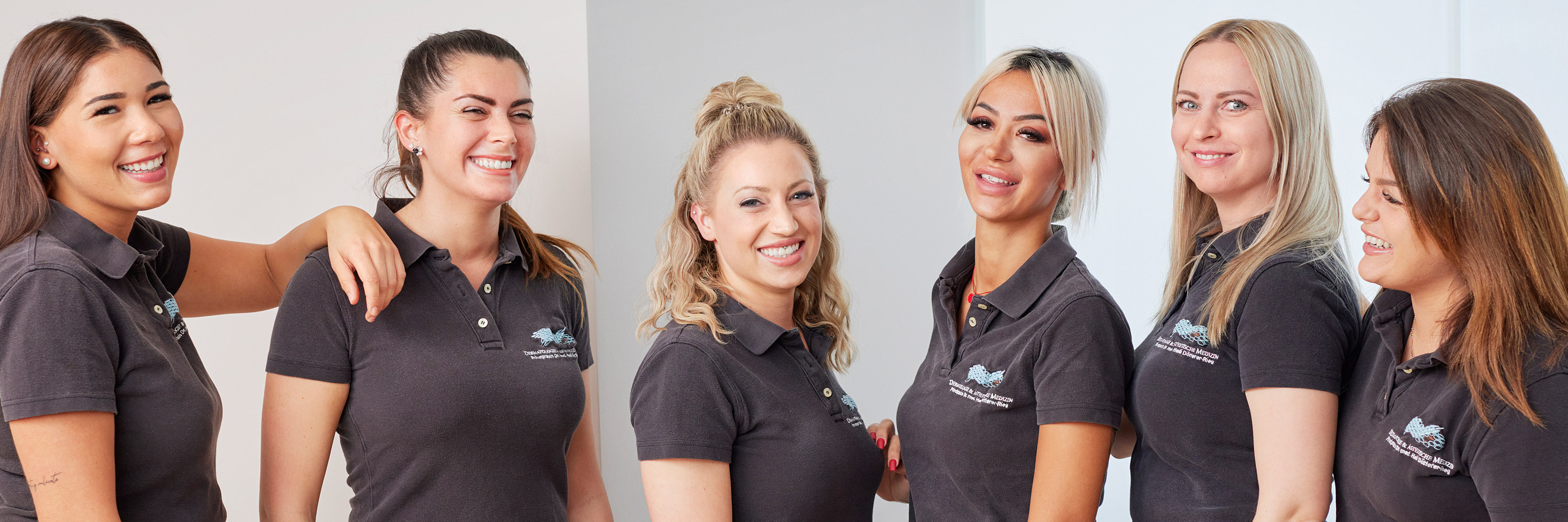 Employee of the specialist practice for dermatology, phlebology and allergology in Frankfurt. Six medical assistants happily stand in front of the camera as a team. They are dressed uniformly and carry the symbol of the dermatology practice.